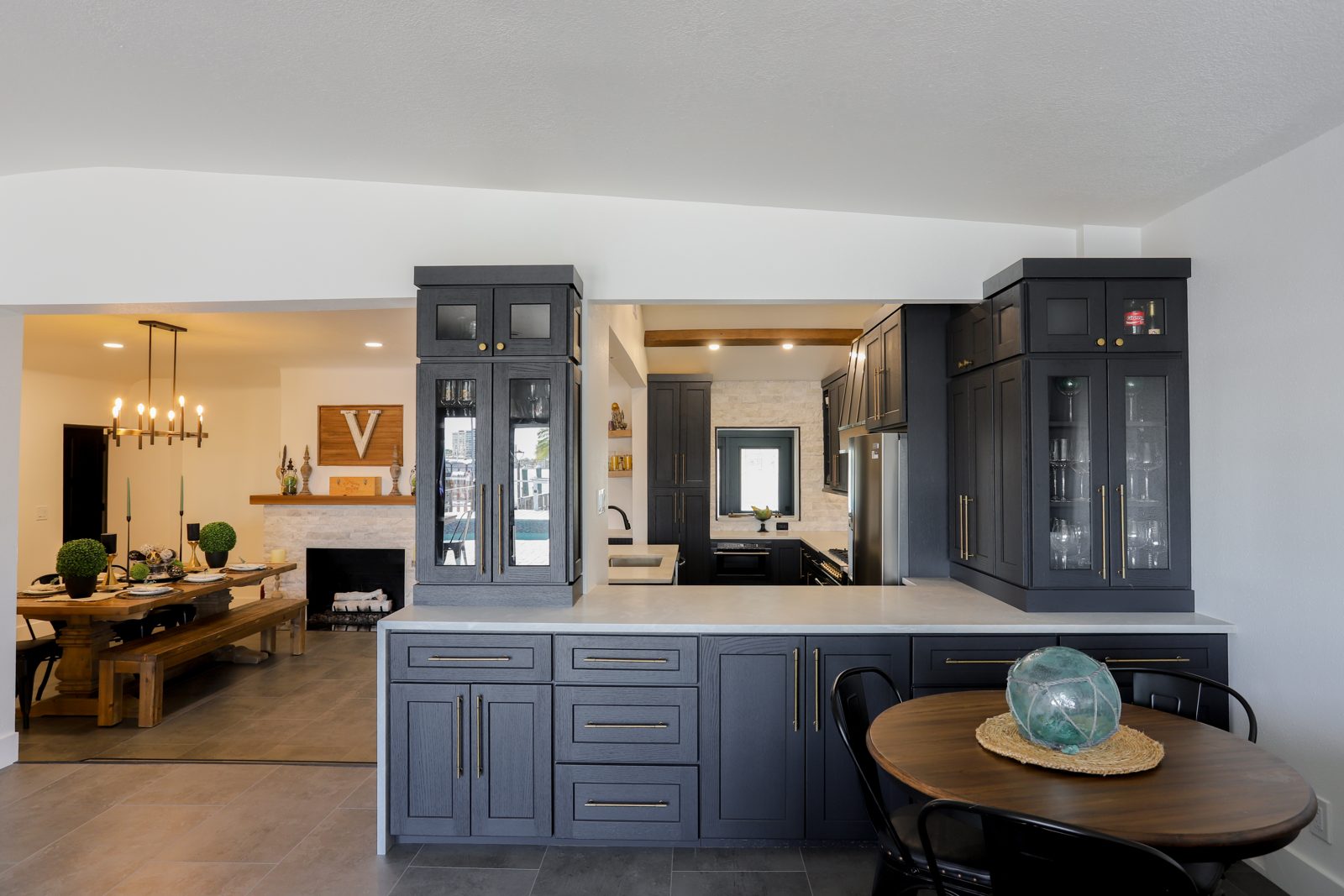 Open-concept luxury kitchen and dining room with navy cabinetry by St. Petersburg custom home builder
